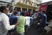Equipa médica transporta paciente numa maca para ambulância