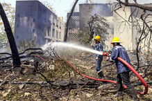Bombeiros combatem incêndio num edifício com mangueiras
