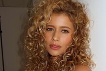 Retrato de mulher com cabelo encaracolado e camisa preta