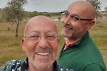 Dois homens sorriem num campo soalheiro