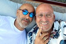 Dois homens sorriem para a câmara com óculos de sol