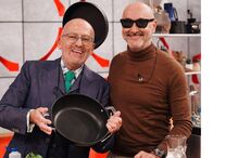 Dois homens sorridentes preparam receita na cozinha