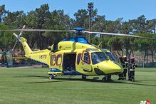 Helicóptero do INEM com equipa de bombeiros junto à aeronave