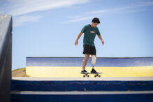 Homem anda de skate com uma prótese numa pista de skate