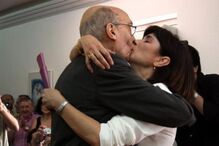 Casal demonstra afeto com beijo em público, sob olhares atentos