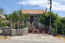 Casa rústica com portão de ferro e jardim florido na fachada