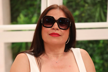 Mulher com óculos de sol e batom vermelho posa para a câmara