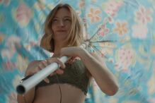 Mulher com um top verde e um guarda-sol colorido