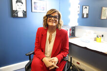 Retrato de Júlia Pinheiro num camarim com luzes e fotos na parede