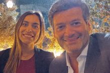 Retrato de Ricardo Rio com uma mulher sorridente num ambiente iluminado