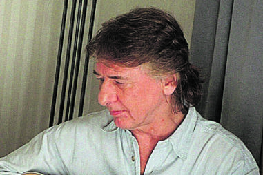 Mick Ralphs, guitarrista, toca um instrumento.
