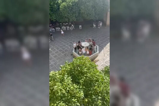 Turistas portugueses a dançar dentro de fonte no centro histórico de Sevilha em Espanha indignam população