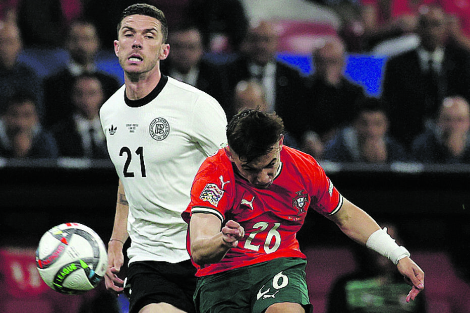 Dois jogadores de futebol competem pela bola num jogo