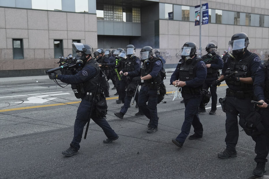 Agentes da polícia fortemente armados patrulham as ruas de Los Angeles