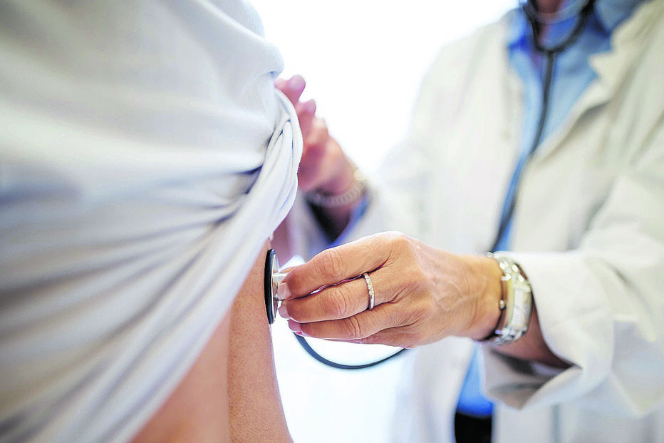 Médico examina paciente, alertando para aumento de casos de listeriose em Portugal.
