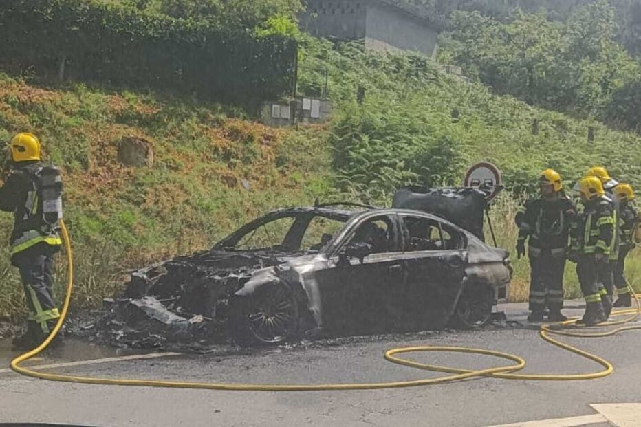 Carro destruído pelas chamas em Braga; bombeiros no local