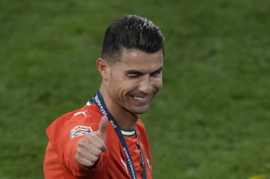 Cristiano Ronaldo sorri com polegar para cima e medalha