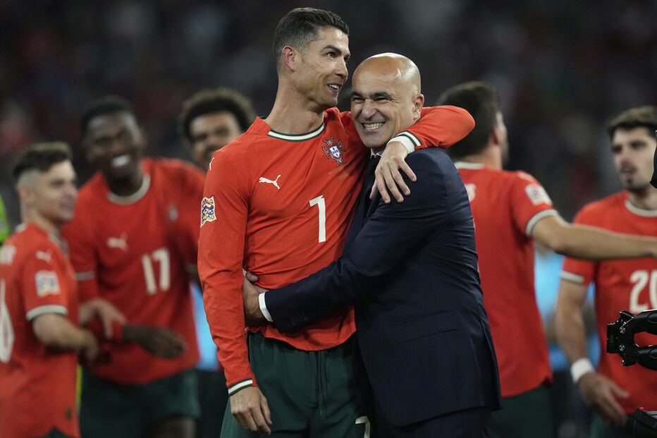 Roberto Martínez abraça Cristiano Ronaldo num jogo de futebol