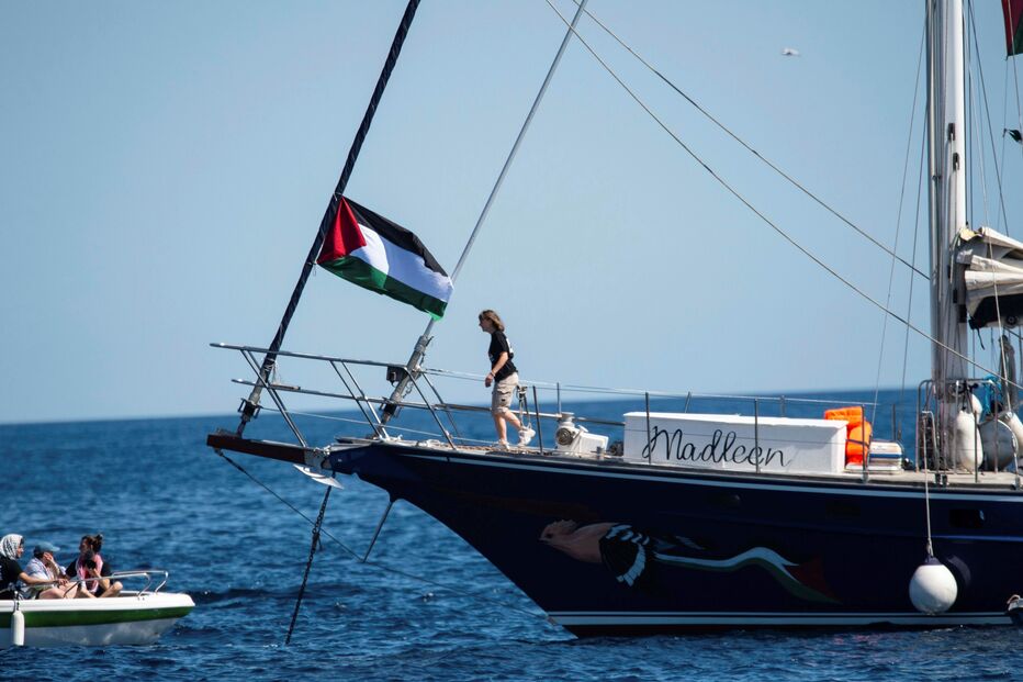 Bandeira da Palestina num barco com o nome Madlecn no mar