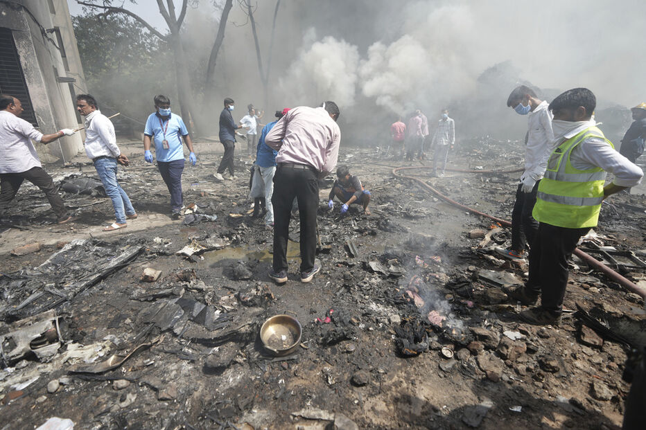 Após incêndio, pessoas avaliam os danos no local
