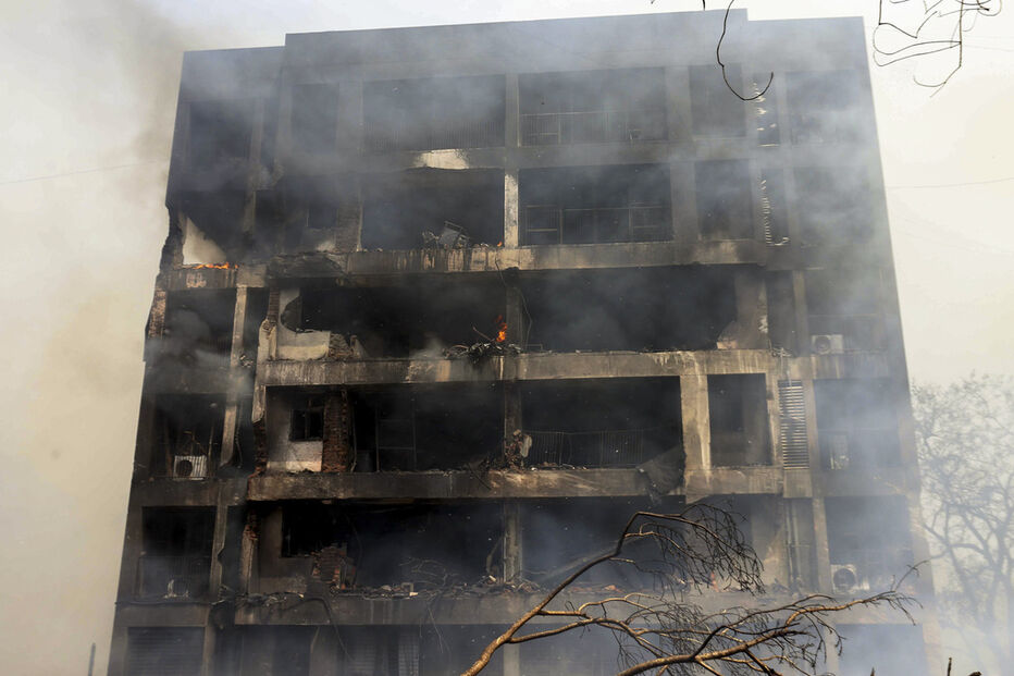 Edifício com estragos e fumo após incêndio