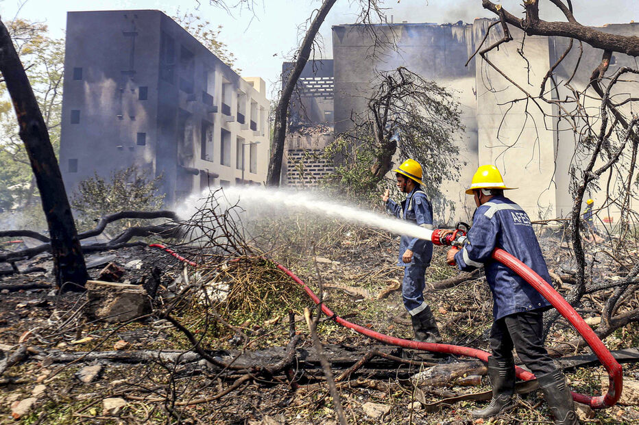 Bombeiros combatem incêndio num edifício com mangueiras