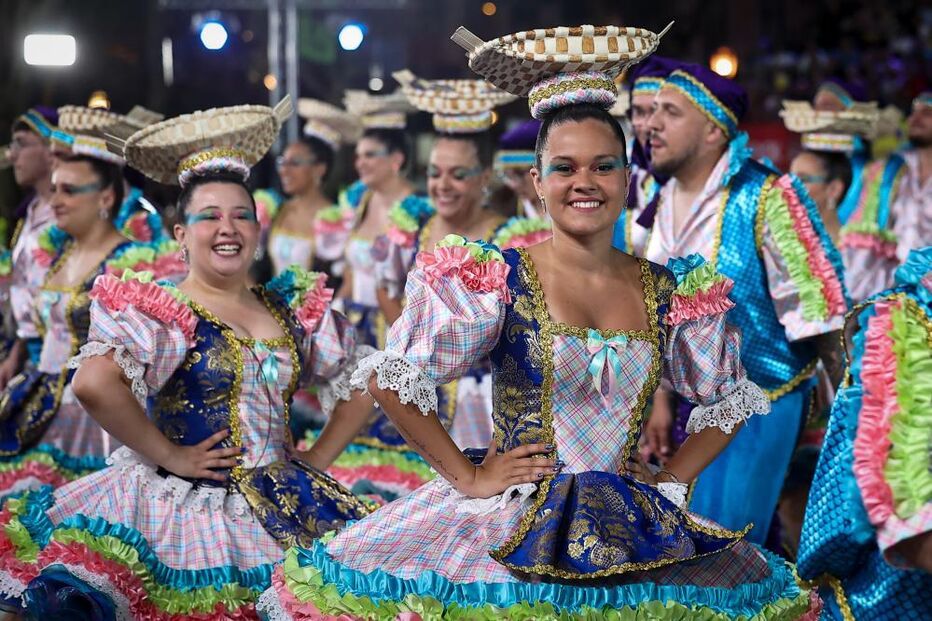Pessoas celebram festa popular com trajes típicos e coloridos