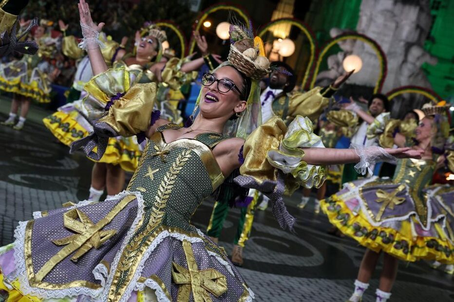 Grupo de pessoas dança em evento cultural com trajes típicos