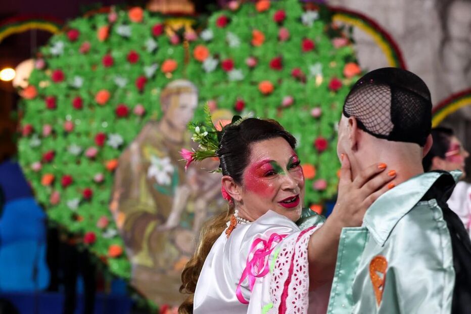 Pessoas com pinturas faciais e trajes festivos celebram num evento