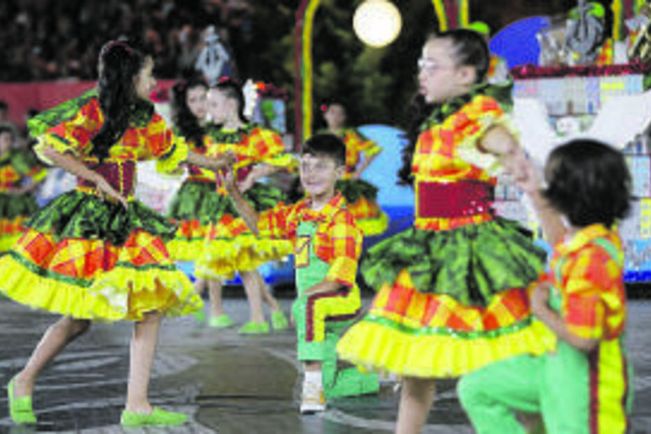 Crianças atuam com trajes coloridos durante festival