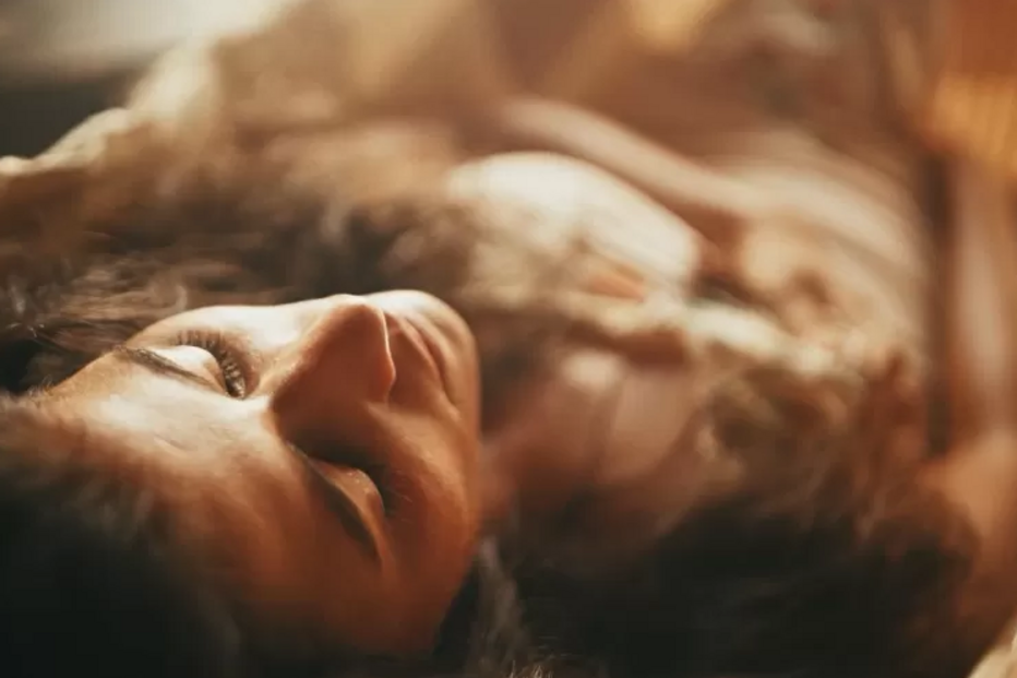 Uma mulher repousa, olhos fechados, num momento de relaxamento