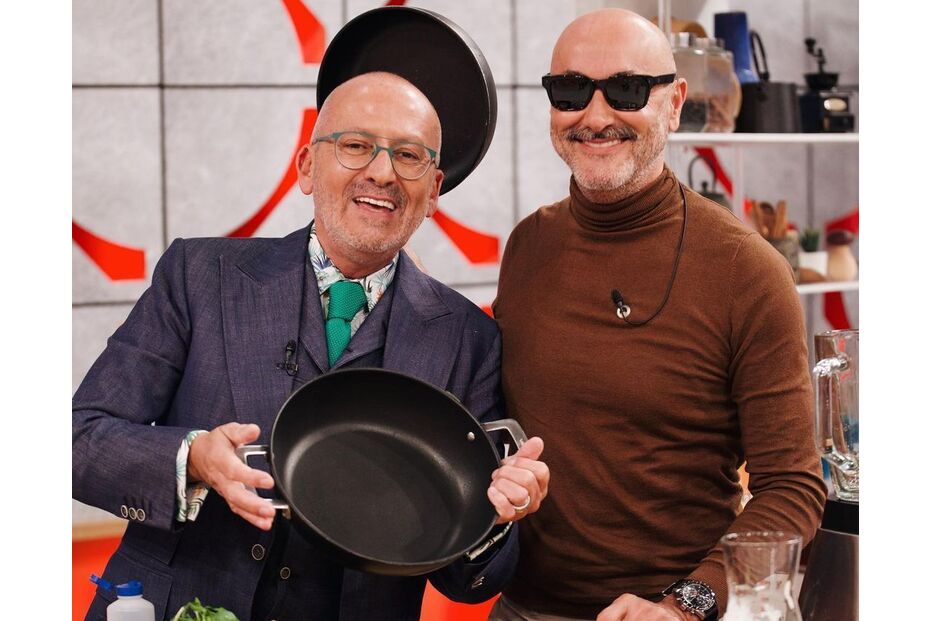 Dois homens sorridentes preparam receita na cozinha