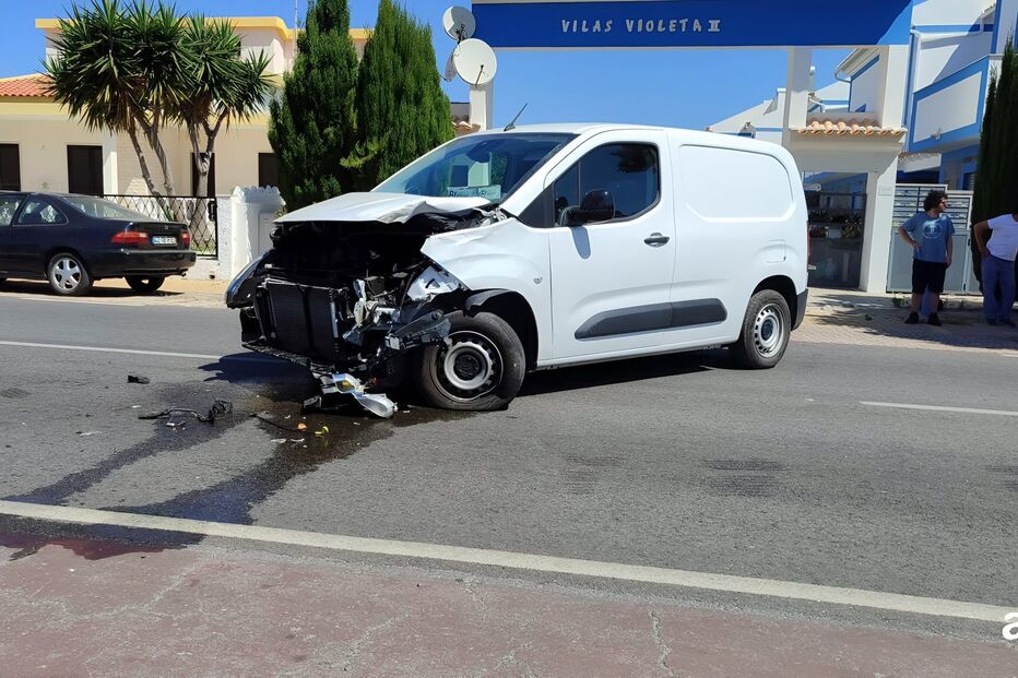 Após acidente, carrinha branca danificada permanece na estrada perto de Vilas Violeta II