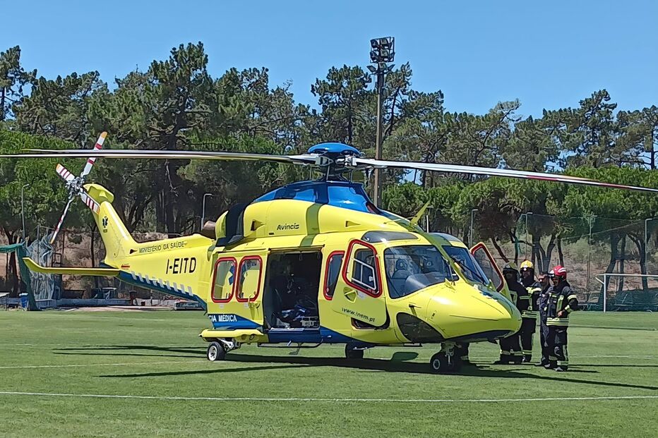 Helicóptero do INEM com equipa de bombeiros junto à aeronave