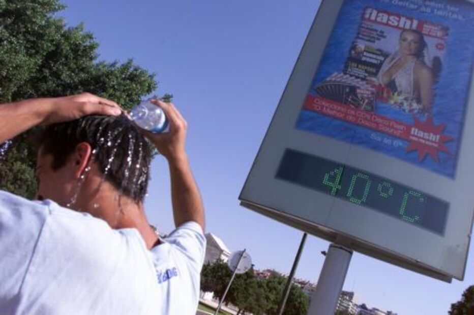 Termómetro marca 40°C, enquanto pessoa tenta refrescar-se