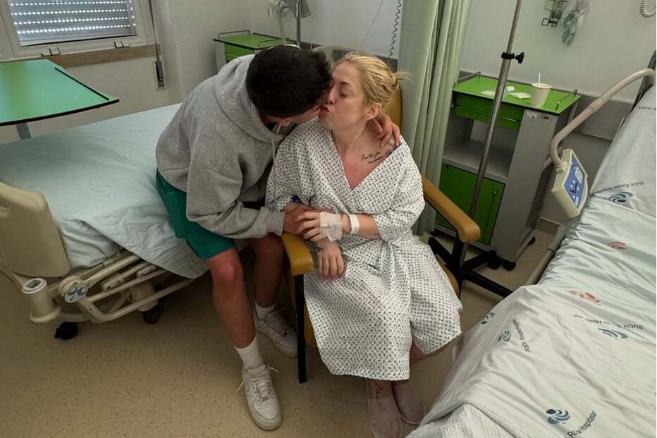 Mulher recebe um beijo de um homem num quarto de hospital