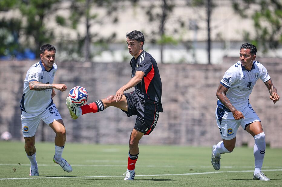 Jogadores disputam a bola durante um jogo de futebol