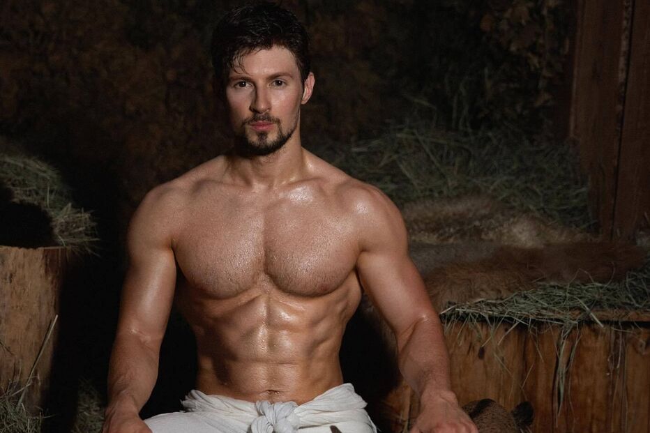 Homem sem camisa com cabras em ambiente rústico