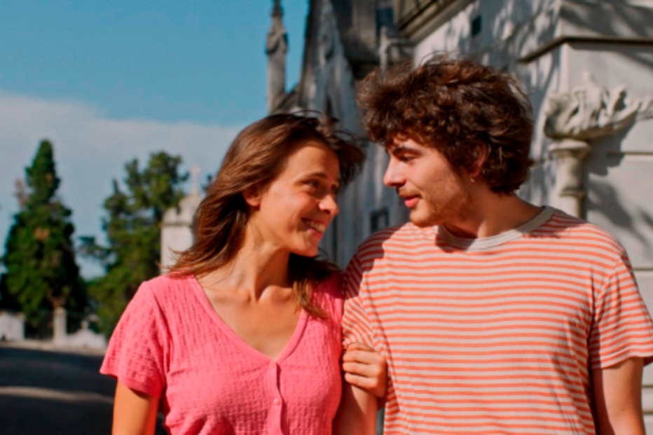 Um casal sorri um para o outro enquanto caminha na rua