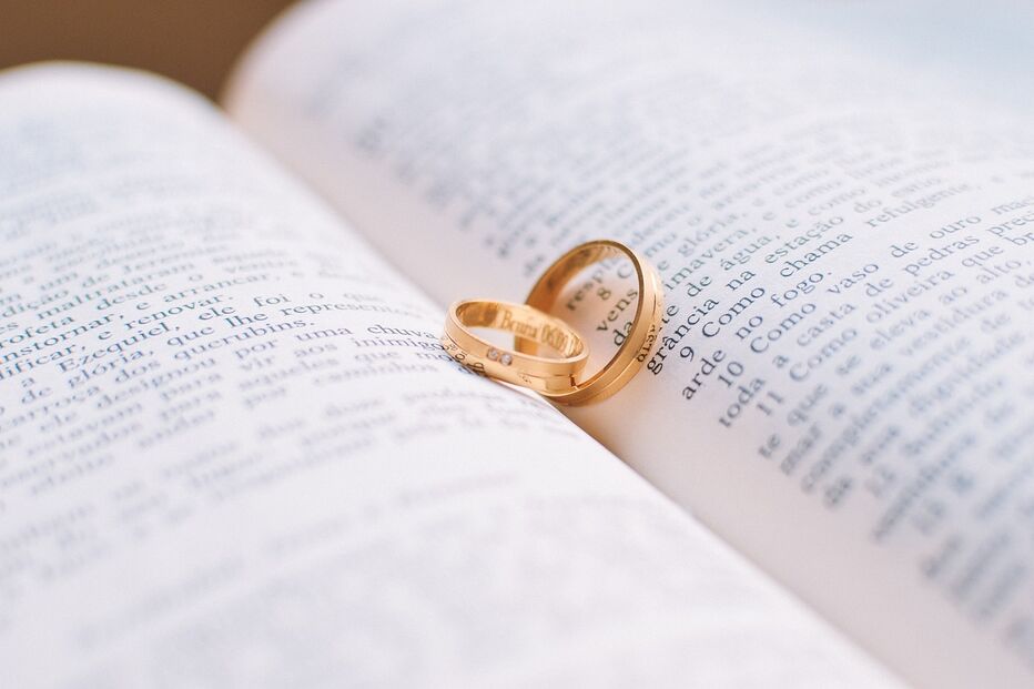 Alianças de casamento pousadas sobre páginas de um livro
