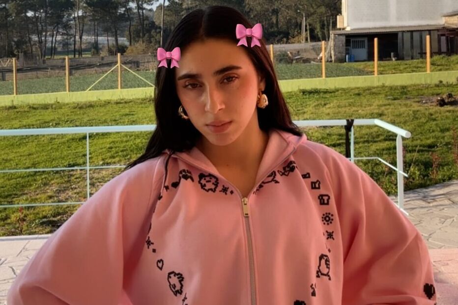 Mulher posa com adereços de cabelo e casaco rosa num espaço exterior