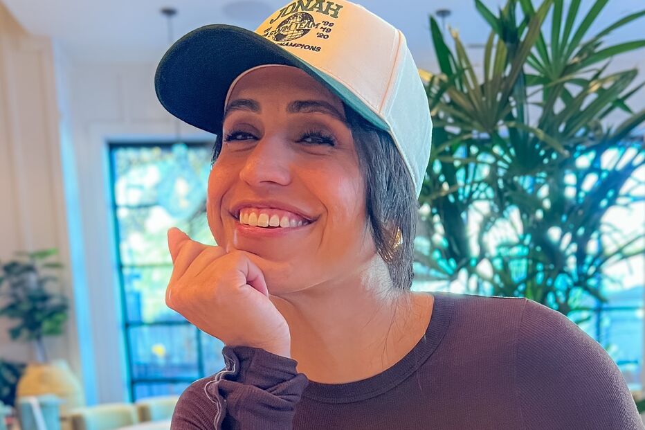 Mulher sorri num restaurante com menu de bebidas na mesa