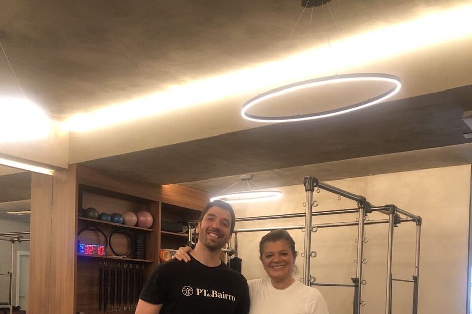 Duas pessoas posam num estúdio com equipamentos de pilates