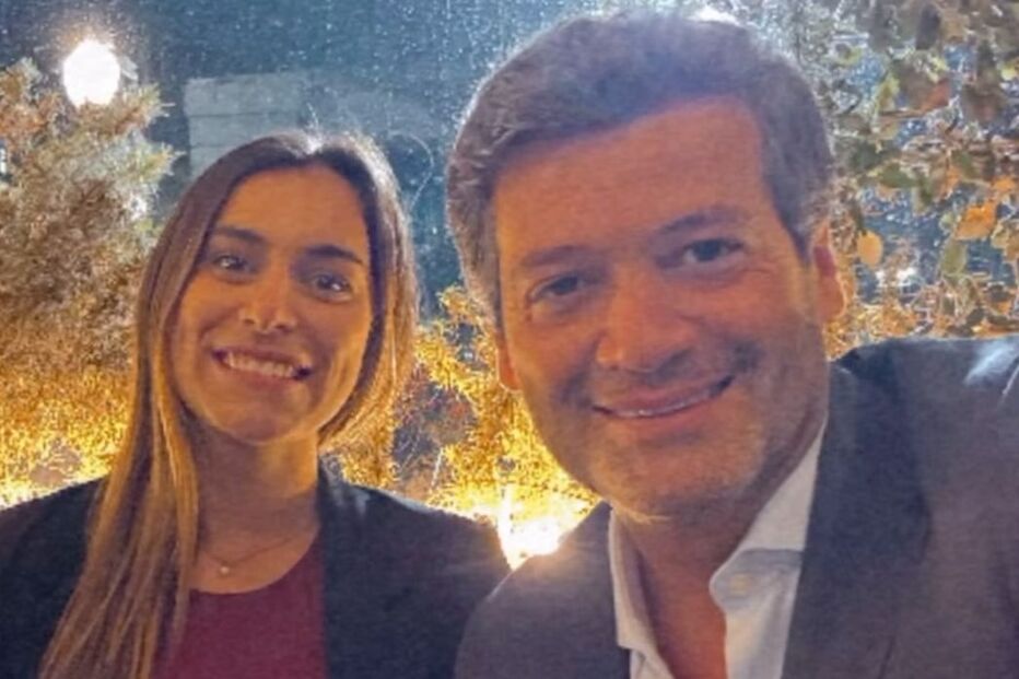 Retrato de Ricardo Rio com uma mulher sorridente num ambiente iluminado