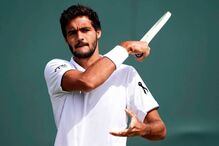 Tenista exibe fita preta em homenagem, empunhando raquete