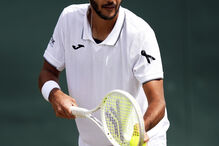 Jogador de ténis prepara-se para servir num court