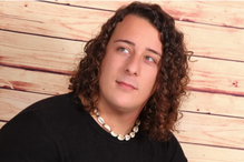 Retrato de homem de cabelo encaracolado, com colar de conchas e pulseiras