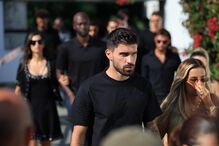 Grupo de pessoas vestidas de preto num funeral