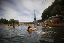 Banhistas aproveitam reabertura do rio Sena em Paris, perto da Torre Eiffel