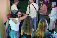 Pessoas reunidas num evento; abraços e sorrisos entre convívio